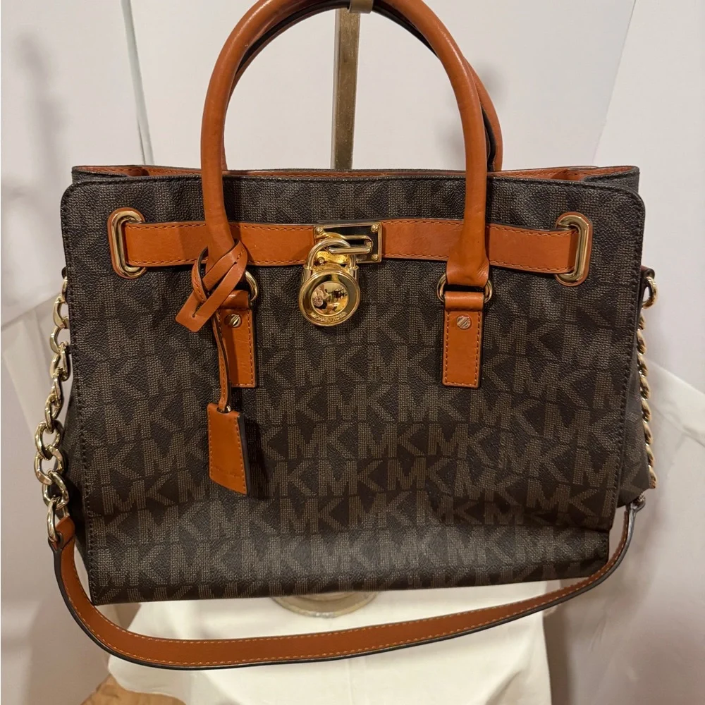 Michael Kors Emblemed satchel style purse. Strap has some gold chain and leather